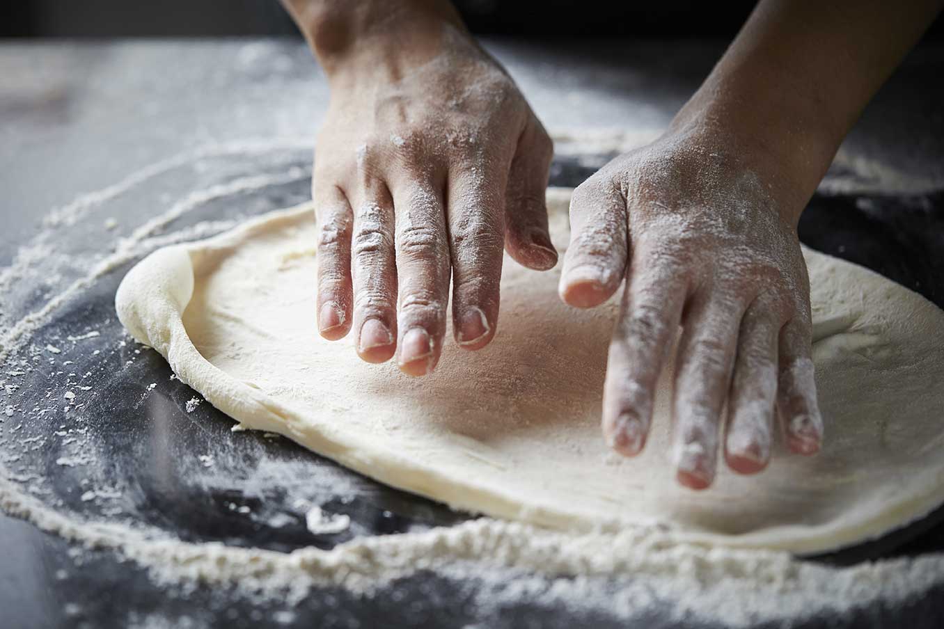 Pizzateig wird von Hand geformt